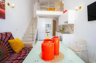 a living room with two orange trash cans on a table at MARÍTIMO28 in Cádiz