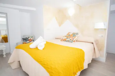 a bedroom with a yellow bed and a window at MARÍTIMO28 in Cádiz