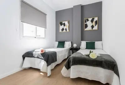a bedroom with two beds and a window at LalaSuites RIANAL in Jerez de la Frontera