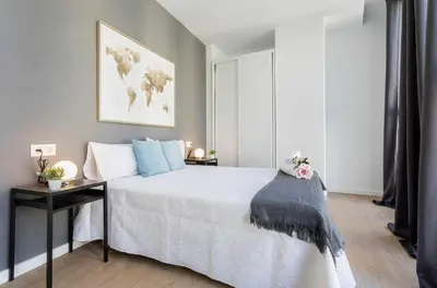 a bedroom with a large white bed with a desk at LalaSuites RIANAL in Jerez de la Frontera