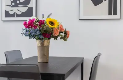 a vase of flowers sitting on top of a table at LalaSuites RIANAL in Jerez de la Frontera