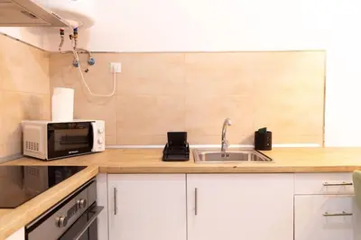 a kitchen with a sink and a microwave at La Gloria in Cádiz