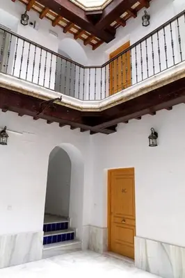 an empty room with a staircase and a wooden door at La Gloria in Cádiz