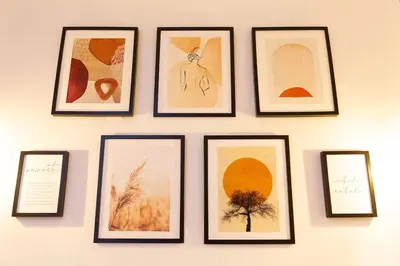 a group of framed pictures on a wall at La Gloria in Cádiz