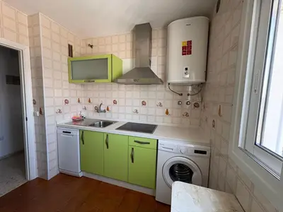 a kitchen with green cabinets and a washing machine at APARTAMENTO VISTAS AL MAR - Valdelagrana Playa in El Puerto de Santa María