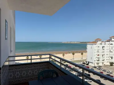 a balcony with a view of the beach and buildings at APARTAMENTO VISTAS AL MAR - Valdelagrana Playa in El Puerto de Santa María