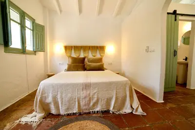 a bedroom with a large bed in a room at Alojamiento rural CASAPIÑA in Conil de la Frontera