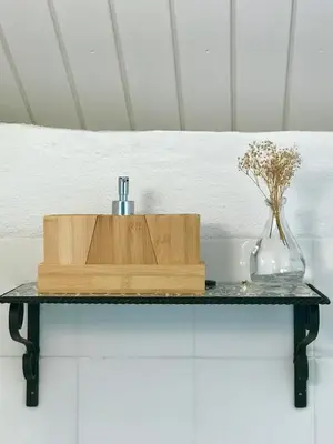 a shelf with a vase and a bottle on a table at Alojamiento rural CASAPIÑA in Conil de la Frontera