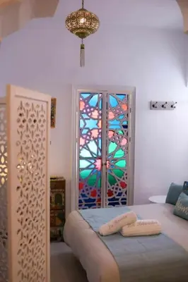 a bedroom with a stained glass window and a bed at La Boveda de Hércules in Medina Sidonia