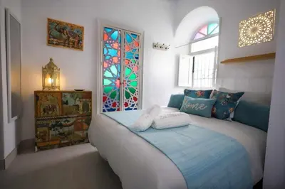 a bedroom with a bed and a stained glass window at La Boveda de Hércules in Medina Sidonia