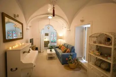 a living room with a blue couch and a table at La Boveda de Hércules in Medina Sidonia