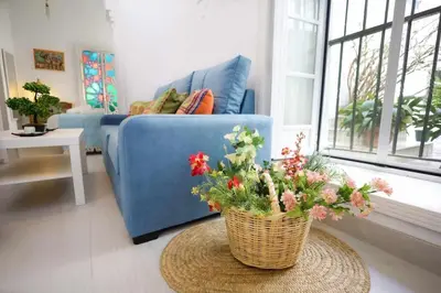 a living room with a blue couch and a basket of flowers at La Boveda de Hércules in Medina Sidonia