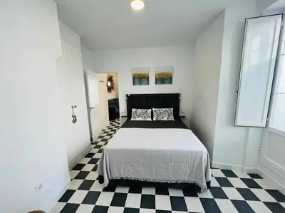 a bedroom with a bed and a checkered floor at Casa Las 4 Esquinas by Casas con Encanto in Medina Sidonia