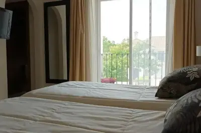 a bedroom with two beds and a large window at Casa Los Olivos in Arcos de la Frontera