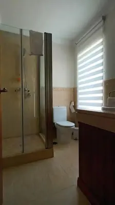 a bathroom with a toilet and a glass shower at Casa Los Olivos in Arcos de la Frontera