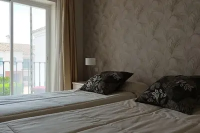 a bed with two pillows and a window in a room at Casa Los Olivos in Arcos de la Frontera