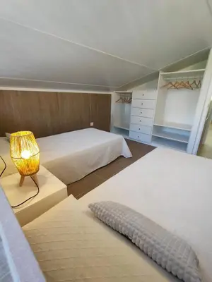 a bedroom with a large white bed and a lamp at Apartamento Mistral 5, con piscina y parking. in Chiclana de la Frontera