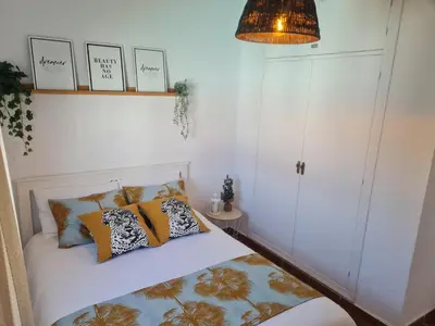 a bedroom with a bed with pillows and a lamp at Villa Encanto in Chiclana de la Frontera
