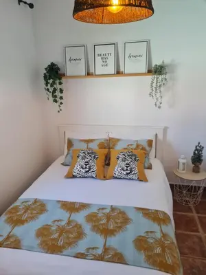 a bedroom with a bed with yellow pillows at Villa Encanto in Chiclana de la Frontera