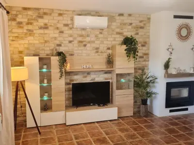 a living room with a tv on a brick wall at Villa Encanto in Chiclana de la Frontera