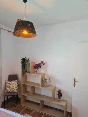 a living room with a pendant light and a chair at Villa Encanto in Chiclana de la Frontera