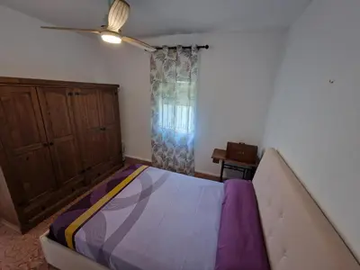 a bedroom with a bed and a ceiling fan at DULCE CARMEN in Bonanza