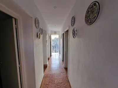 a hallway with plates on the walls of a house at DULCE CARMEN in Bonanza