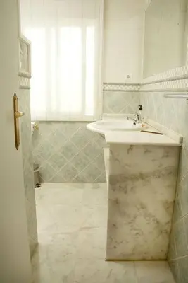 a white bathroom with a sink and a window at Duplex Las Torres La Barrosa 3Beds - A 700m de la playa in Chiclana de la Frontera