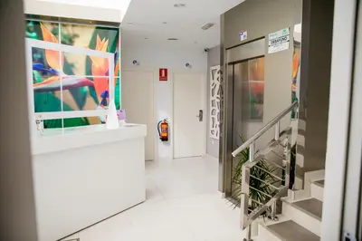 a hallway in a building with a staircase and paintings at Apartahotel Énfasis-Group in El Cuervo