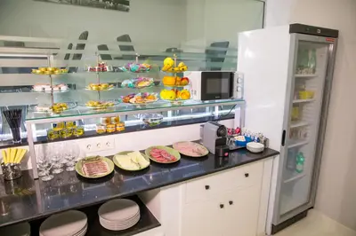 a kitchen with plates on a counter with a refrigerator at Apartahotel Énfasis-Group in El Cuervo