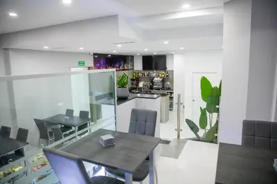 a dining room with a table and a kitchen at Apartahotel Énfasis-Group in El Cuervo