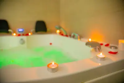 two candles sitting on a bath tub with lights at Apartahotel Énfasis-Group in El Cuervo