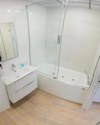 a white bathroom with a shower and a sink at Apartahotel Énfasis-Group in El Cuervo