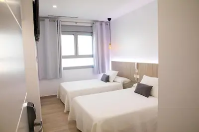 a hotel room with two beds and a window at Apartahotel Énfasis-Group in El Cuervo