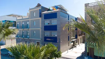 a tall building with palm trees in front of it at Apartahotel Énfasis-Group in El Cuervo