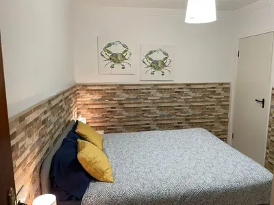 a bedroom with a bed and a brick wall at Casa Oceano in San Fernando