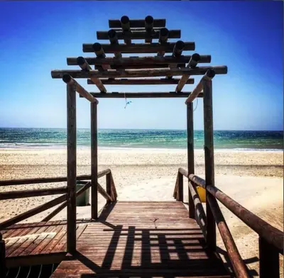 a wooden boardwalk on a beach with the ocean at Casa Oceano in San Fernando