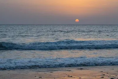 a sun setting over the ocean with the beach at Casa Oceano in San Fernando