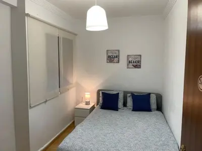 a bedroom with a bed with blue pillows and a window at Casa Oceano in San Fernando