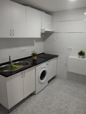 a kitchen with a sink and a washing machine at piso pilar in Chiclana de la Frontera