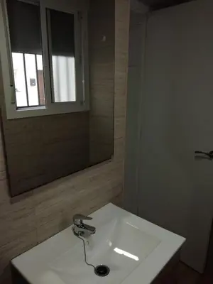 a bathroom with a white sink and a mirror at piso pilar in Chiclana de la Frontera