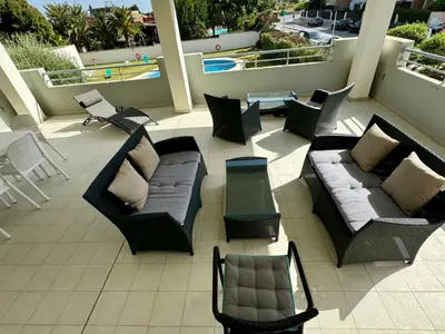 a patio with couches and chairs on a balcony at Casa La Camelia con Piscina Grupo AC Gestión in El Puerto de Santa María
