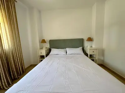 a bedroom with a large white bed with two night stands at Casa La Camelia con Piscina Grupo AC Gestión in El Puerto de Santa María