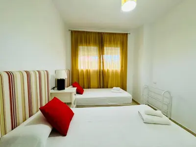 a bedroom with two beds and a window at Casa La Camelia con Piscina Grupo AC Gestión in El Puerto de Santa María