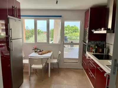 a kitchen with a table with chairs and a window at Casa La Camelia con Piscina Grupo AC Gestión in El Puerto de Santa María