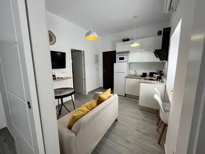 a living room and kitchen with a couch and a table at Apartamento 29 in Arcos de la Frontera