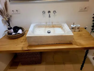 a stone sink on a wooden counter in a bathroom at Casa del Museo - Agua in Medina Sidonia