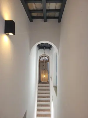 a hallway with stairs leading to a wooden door at Casa del Museo - Agua in Medina Sidonia