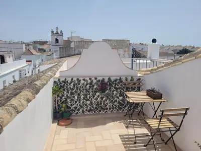 a balcony with a table and chairs on a roof at Casa del Museo - Agua in Medina Sidonia
