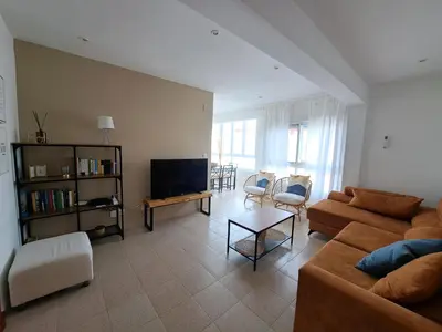 a living room with a couch and a tv at Ático primera línea de playa con vistas al Mar-Climatizado-Wifi-Parking-Solo familias in El Puerto de Santa María